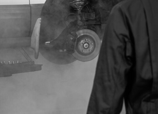 Profesionalus mechanikas tikrina automobilio pakabą techninės apžiūros pasiruošimo metu autoservise.