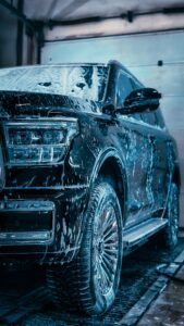Automobilio kėbulo plovimas aktyviosiomis putomis, padedančiomis pašalinti purvą ir apsaugoti dažų sluoksnį.